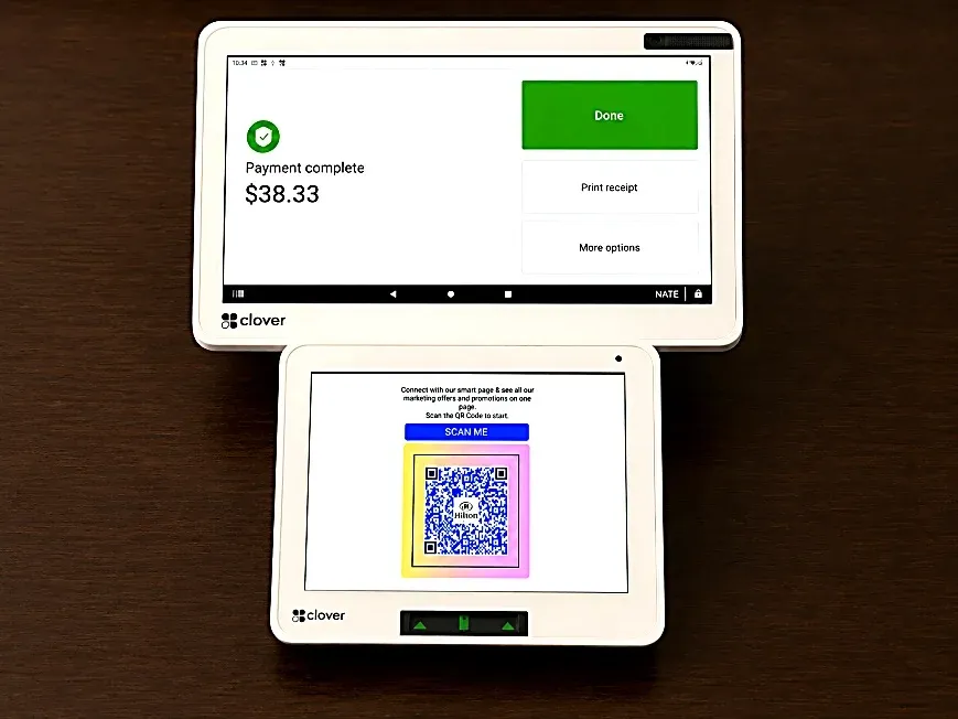 A Clover Station showing payment complete while the customer screen shows a review QR code.
