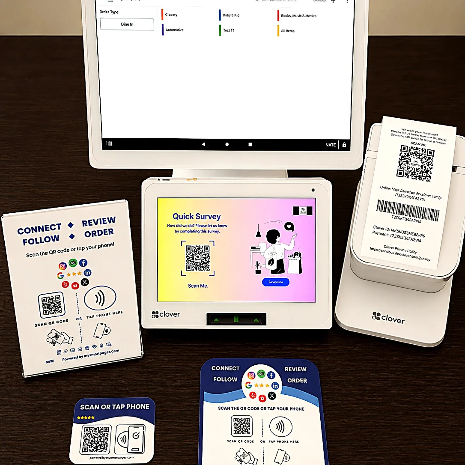 A Clover Station and customer display with POS Marketing review prompts, a receipt QR and NFC stands.